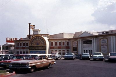 The Showboat casino frontage in 1968 seen across its large parking lot dotted with 1960s cars