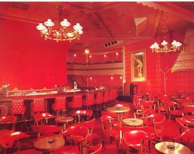 A restored 1954 brochure photograph of the Showboat's red Mardi Gras bar room with a long bar and upholstered stools