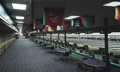 A 1990s postcard photograph of the Showboat bowling concourse with colorful tournament banners hanging from the ceiling above tables and chairs, lanes stretching away at right