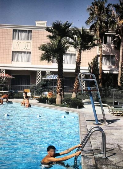 Guests relaxing around the Showboat swimming pool in 1968, photographed in vertical Kodachrome with the hotel buildings behind